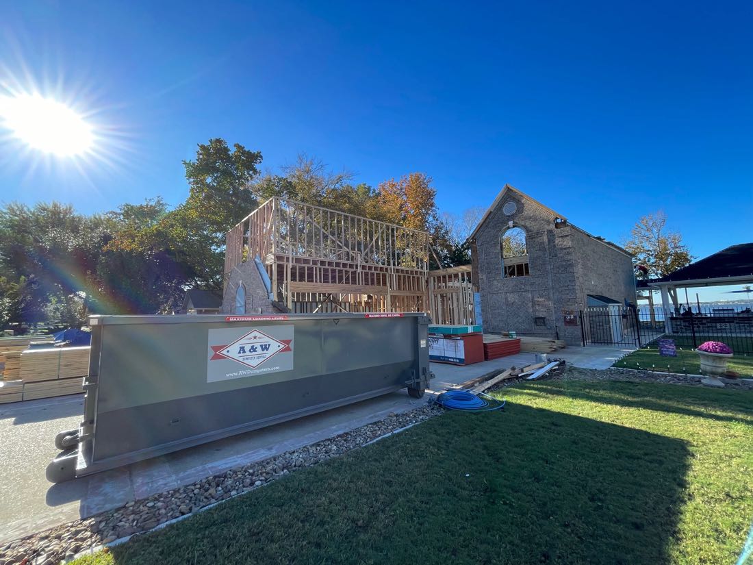 A&W branded roll-off dumpster at a lakefront new-construction build